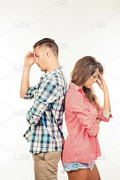 一对年轻情侣背靠背站着，无视对方