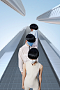 This may contain: three people with black hair and white bodysuits standing in front of tall buildings