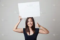 年轻的亚洲女性竖起大拇指，示意空白。