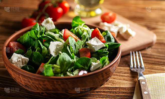 沙拉由生菜叶、绿豆、奶酪、圣女果，在陶瓷碗里放在木板上特写(野樱草)。饮食健康，素食主义。软的焦点。