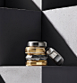 A color photograph shows four David Yurman men’s band rings stacked from the Faceted and Beveled collections. One band from the Faceted collection leans to the left on the stack of four. The Faceted rings are crafted from 18K yellow gold, 18K yellow gold 