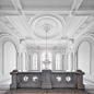 Renovated hall of the old historical building. White walls with golden chandelier.