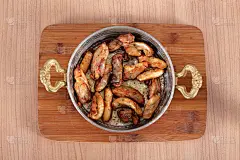 在木桌上的高角度铜碗里盛炸鸡