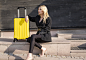 一个优雅的女人带着一个黄色的手提箱在街上旅行图片-商业图片-正版原创图片下载购买-VEER图片库