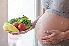 孕妇的肚子里盛着一盘蔬菜。孕期控制体重和健康饮食的概念
