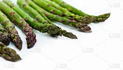 一束新鲜的生芦笋在白色的背景下，素食的概念。绿草雀稗，蔬菜的食物