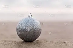 银色圣诞球在海滩日落，假日概念