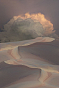 thunder clouds over the dunes, in pink and grey.: 