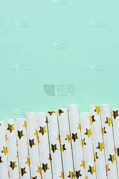 优雅的白纸饮用吸管与金色的星星图案分散为边界上的绿松石背景。生日派对有趣的孩子节日庆祝概念。邀请卡副