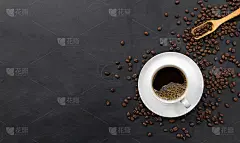 黑木桌的背景上放着一杯咖啡和豆子。俯视图