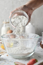 制作薄煎饼、蛋糕、烘焙，面包师双手将面粉倒入碗中。白色大理石餐桌上的烹饪材料和方法的概念。甜点食谱和