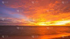 迷人的日落。夕阳中的五彩天空。自然日落日出在田野或草地。明亮戏剧性的天空和黑暗的地面。