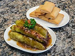 中国食品，上海风格的青椒与卤馅猪肉特写与模糊的春卷背景。