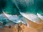 Drone aerial view of the waves crashing on the sand beach at Snapper Rocks Road