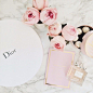 Dior, perfume, and a pile of flowers.: 
