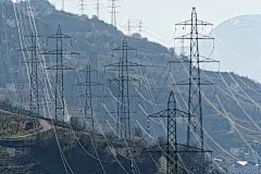 高山背景下的高压线塔在一天结束的时候