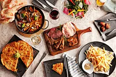 俯视角度拍摄的餐桌上的红酒与各式美食