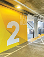 an empty parking garage with yellow and white signs