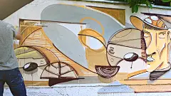 这位艺术家在篱笆上画涂鸦。