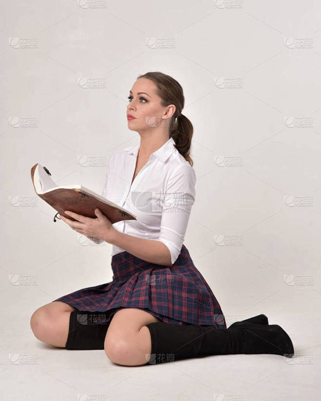 一个黑发女孩穿着白色衬衫和格子裙制服的全...