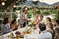 Best man pouring champagne into flutes during wedding reception in domestic garden - stock photo