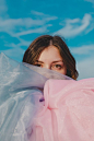 An emotional and moody portrait, shot against a blue sky backdrop in a field in Hertfordshire.  This image was taken by Sian Parker, a UK-based Portraiture Photographer, specialising in experimental, lifestyle and slow living portraiture. Click the image 