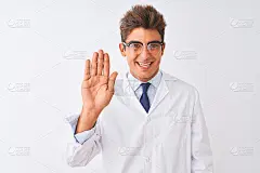 年轻英俊的科学家男子戴着眼镜和外套在孤立的白色背景说你好，快乐和微笑，友好的欢迎手势