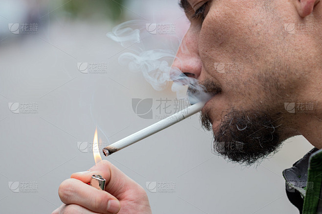 男人在户外点燃一支香烟。